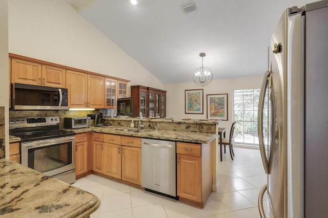 kitchen with visible vents, light stone countertops, appliances with stainless steel finishes, a peninsula, and a sink