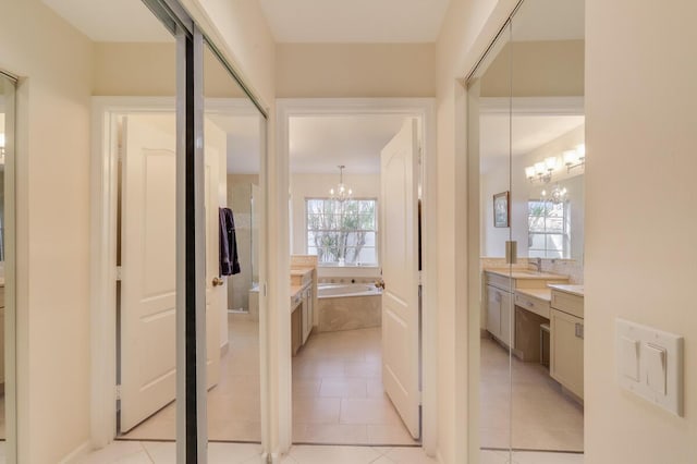 interior space with light tile patterned floors, a notable chandelier, and a sink