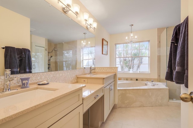 bathroom with a sink, a shower stall, double vanity, and a chandelier