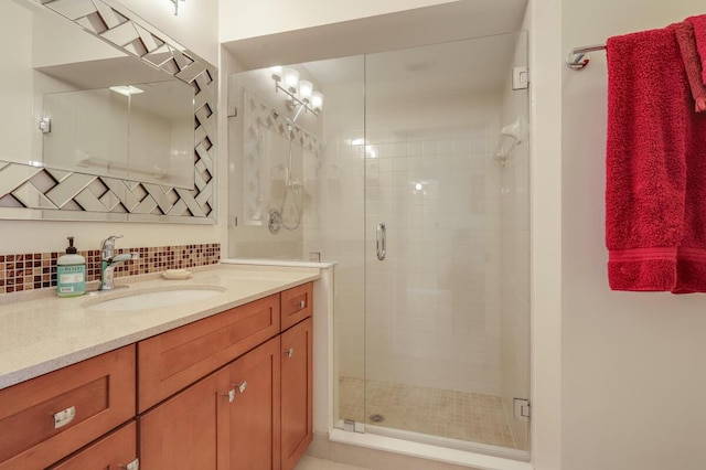 bathroom with vanity, a shower stall, and backsplash