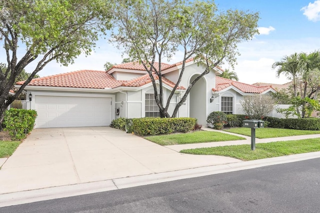 mediterranean / spanish house featuring stucco siding, a front lawn, concrete driveway, a garage, and a tiled roof