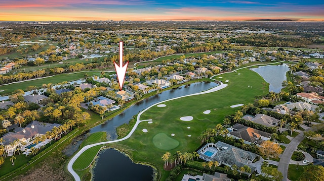 drone / aerial view with a residential view, view of golf course, and a water view