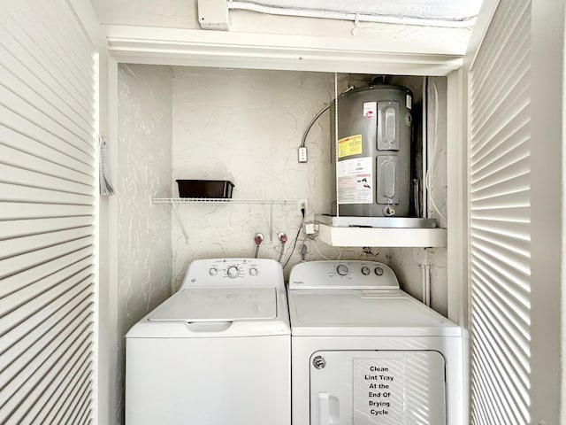 clothes washing area with laundry area, water heater, and washing machine and clothes dryer