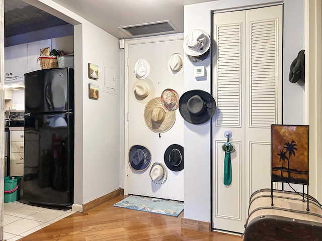 room details with visible vents, baseboards, wood finished floors, and freestanding refrigerator