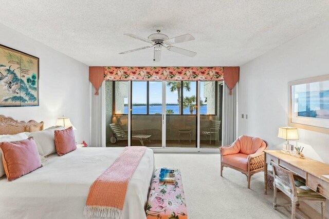 bedroom featuring access to exterior, a textured ceiling, ceiling fan, and carpet floors