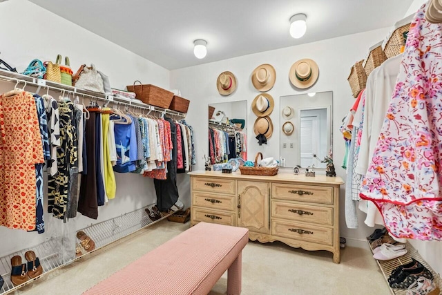 walk in closet with light colored carpet