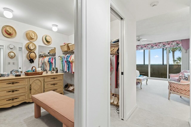 spacious closet featuring light colored carpet and a ceiling fan