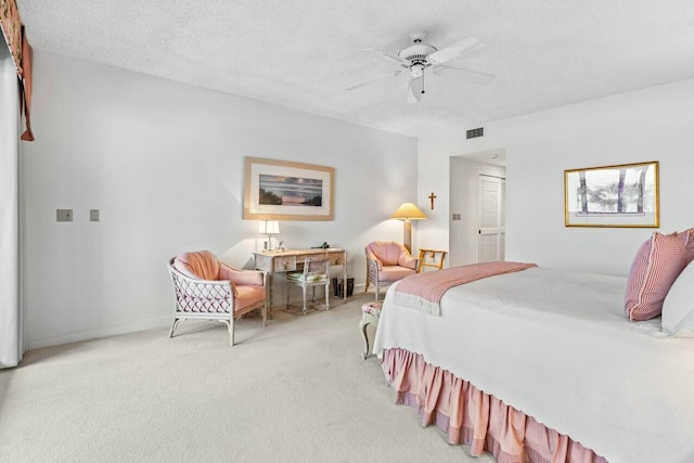 bedroom with visible vents, baseboards, ceiling fan, light carpet, and a textured ceiling