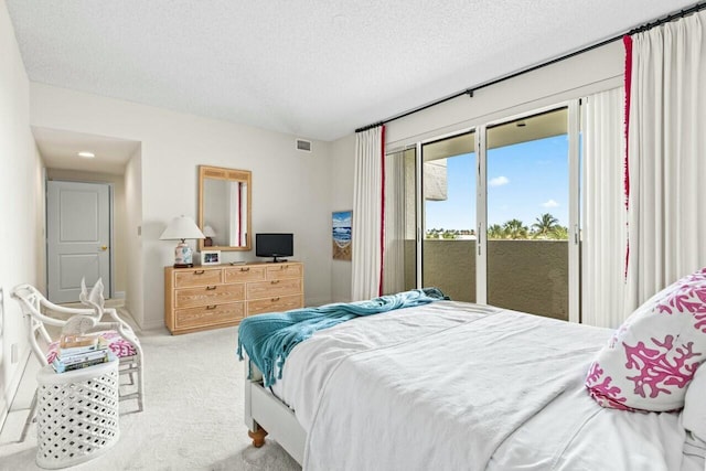 carpeted bedroom featuring visible vents, baseboards, a textured ceiling, and access to outside