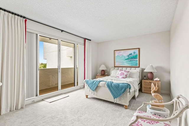 bedroom featuring access to outside, carpet, and a textured ceiling