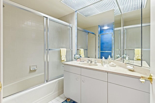 full bath featuring tile patterned flooring, vanity, and shower / bath combination with glass door