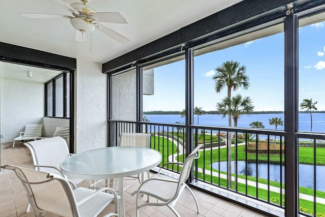 sunroom / solarium with a water view and ceiling fan