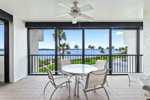 sunroom / solarium featuring a water view and ceiling fan