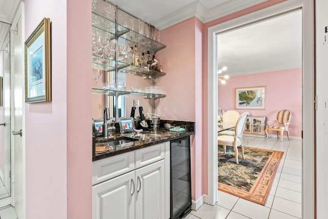 bar with beverage cooler, a sink, crown molding, light tile patterned floors, and wet bar