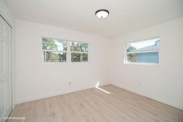 unfurnished room with baseboards and light wood finished floors