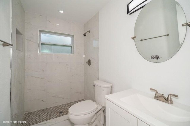 full bathroom featuring vanity, toilet, and tiled shower