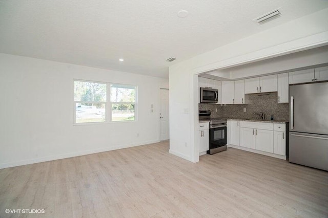 kitchen with tasteful backsplash, visible vents, light wood finished floors, and appliances with stainless steel finishes