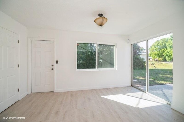 empty room with baseboards and wood finished floors