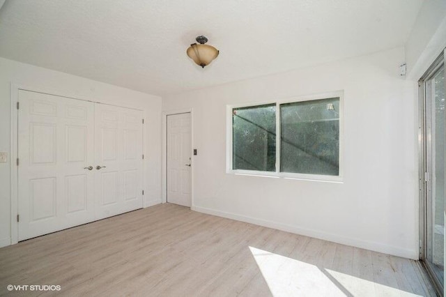 spare room with baseboards and wood finished floors