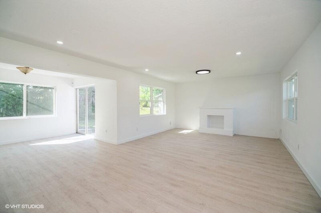 unfurnished living room featuring light wood-style flooring, recessed lighting, and a fireplace