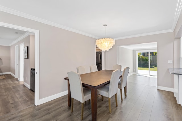 dining room featuring an inviting chandelier, wood finished floors, baseboards, and ornamental molding