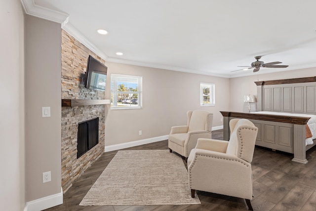 living area with baseboards, a fireplace, dark wood-style flooring, and crown molding