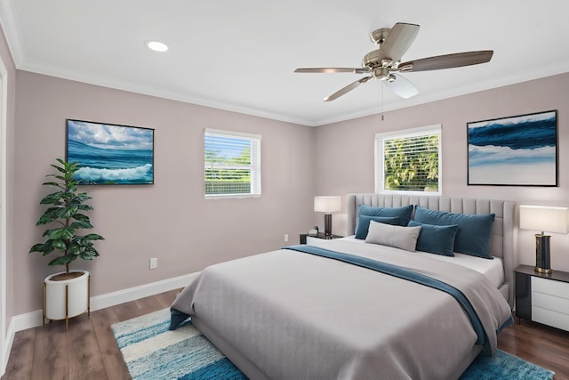 bedroom with multiple windows, wood finished floors, baseboards, and ornamental molding