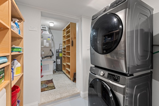 laundry room with laundry area, stacked washer / dryer, and electric water heater