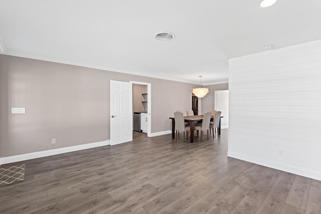 interior space featuring visible vents, dark wood-style floors, an inviting chandelier, crown molding, and baseboards