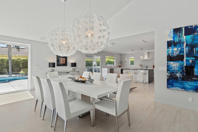 dining area with a wealth of natural light, a chandelier, and light wood-style floors