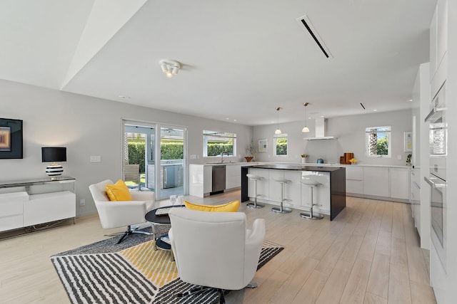 living area featuring recessed lighting, visible vents, plenty of natural light, and light wood-style floors