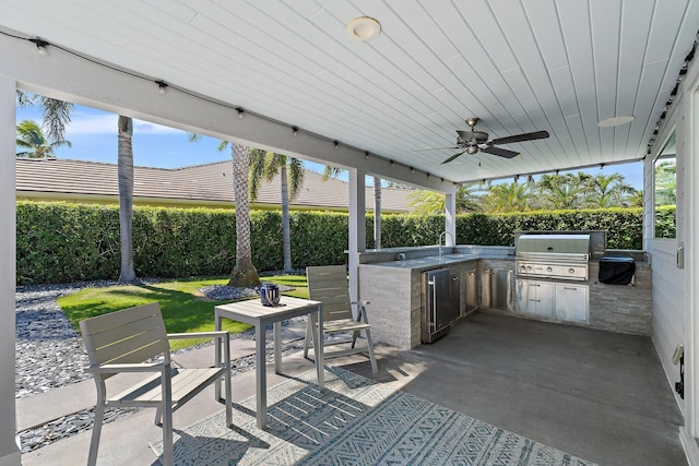 view of patio featuring area for grilling, a fenced backyard, ceiling fan, a sink, and a grill