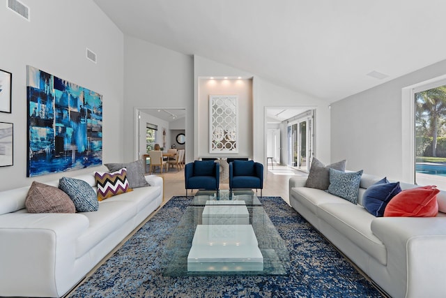 living room with visible vents, high vaulted ceiling, and wood finished floors