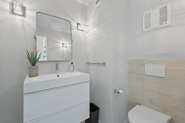 bathroom featuring visible vents, toilet, and vanity