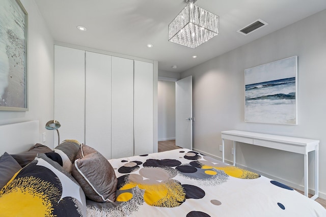 bedroom with visible vents, baseboards, an inviting chandelier, recessed lighting, and a closet