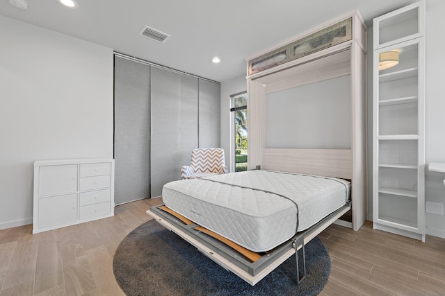 bedroom with light wood finished floors, visible vents, and recessed lighting