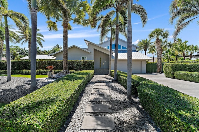 mid-century home featuring driveway, an attached garage, and fence