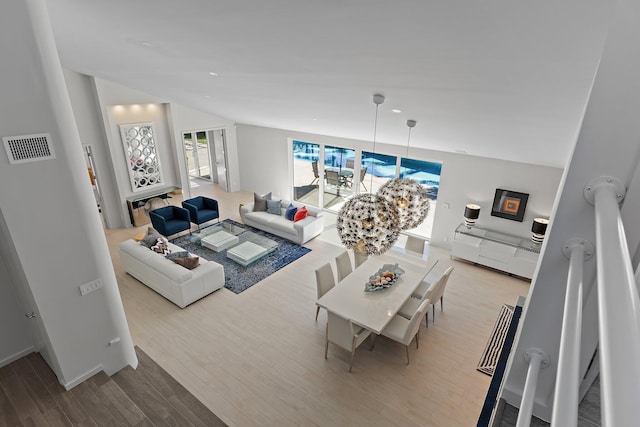 living room featuring lofted ceiling, wood finished floors, and visible vents