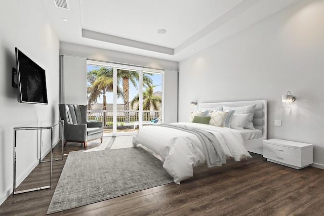 bedroom with wood finished floors, visible vents, recessed lighting, a raised ceiling, and access to outside