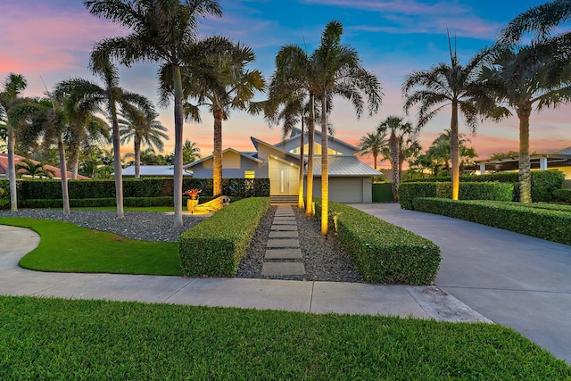 view of front of home featuring an attached garage, a lawn, and driveway