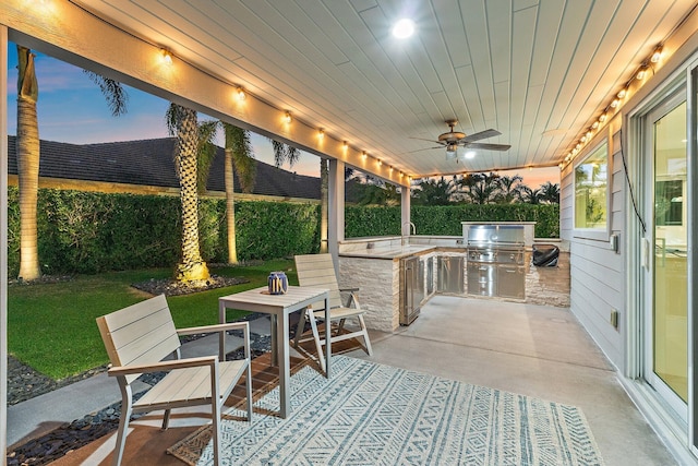 view of patio / terrace featuring ceiling fan, exterior kitchen, a sink, and grilling area