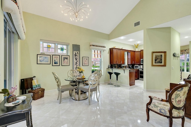 dining area with visible vents, baseboards, high vaulted ceiling, and a chandelier