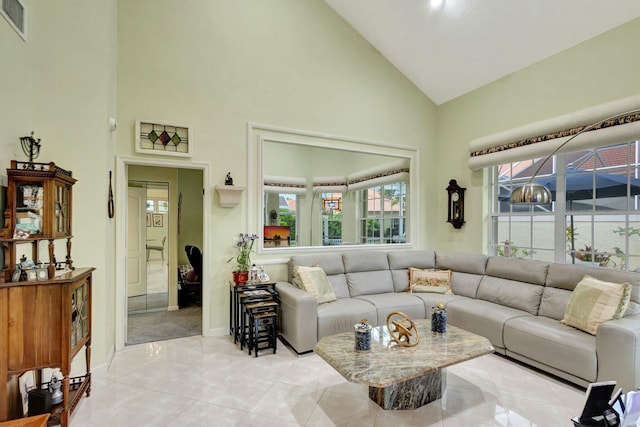 living room featuring visible vents, baseboards, high vaulted ceiling, and tile patterned flooring