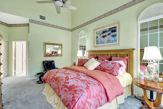 bedroom with baseboards, carpet floors, a high ceiling, and ceiling fan