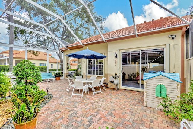 view of patio with glass enclosure and outdoor dining area