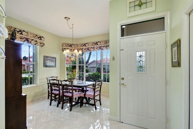 dining room featuring an inviting chandelier, light tile patterned floors, a healthy amount of sunlight, and baseboards