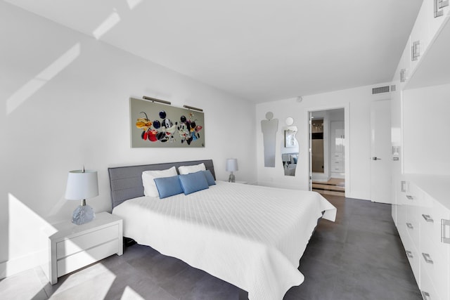 bedroom featuring visible vents, ensuite bath, and finished concrete floors