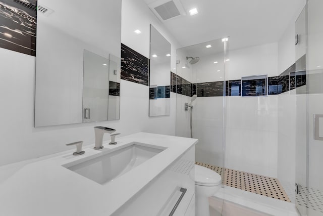 bathroom featuring visible vents, toilet, a stall shower, and vanity