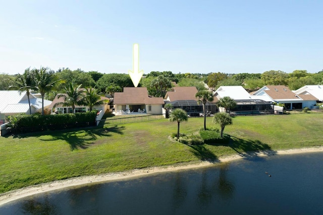 view of front of house with stucco siding, fence, a front yard, and a water view