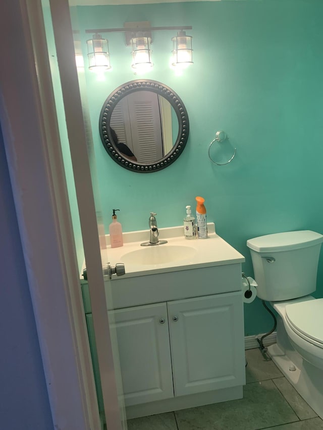 bathroom featuring tile patterned floors, toilet, vanity, and baseboards